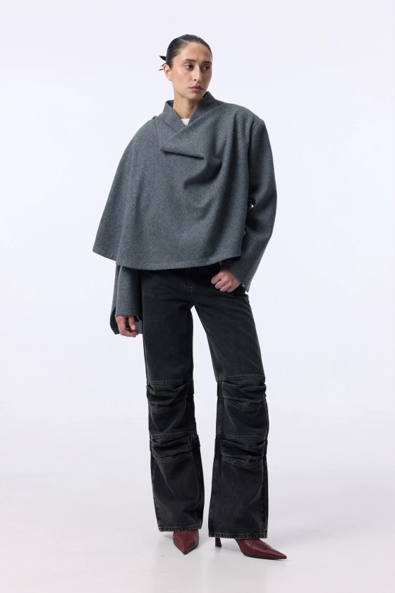 Модель 175 см у сірому пальто-жакеті Frock із чорними брюками, розмір M/L, вид спереду — BÁZHANE